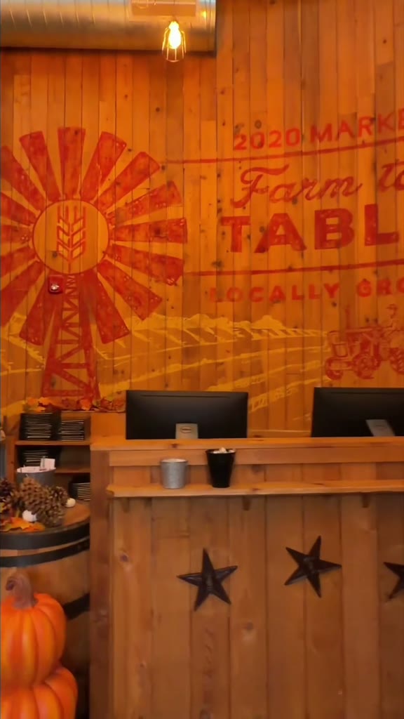 A windmill farm-to-table mural on a wooden wall above the front counter, with pumpkins at the left, inside 2020 Market Scratch Kitchen in Georgetown, Texas.